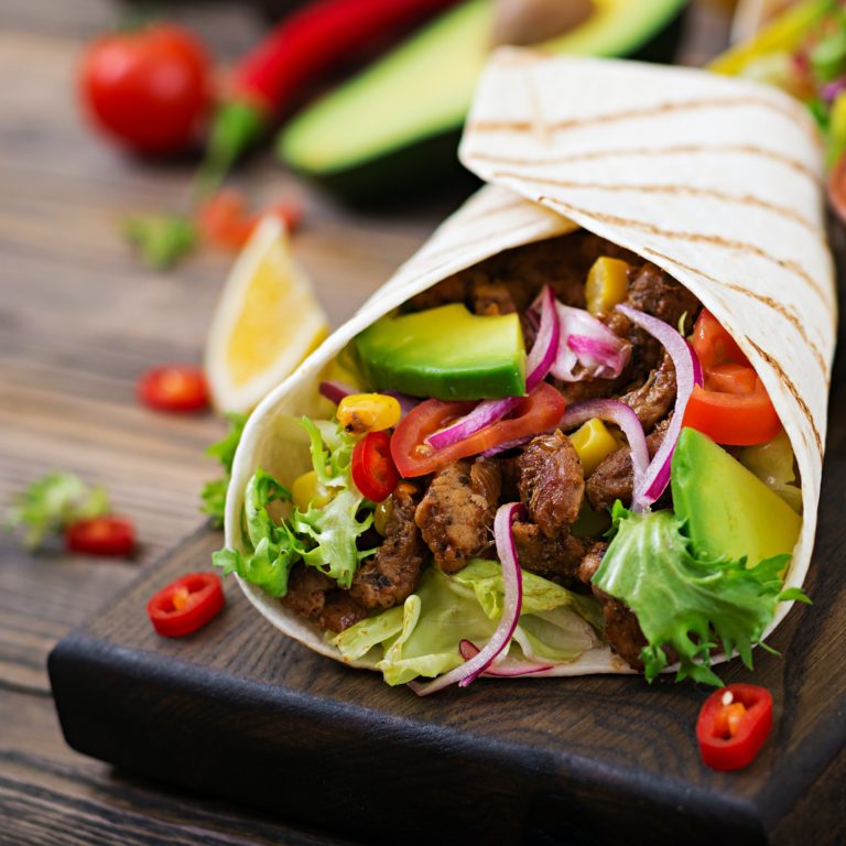 Mexican tacos with beef in tomato sauce and avocado salsa